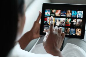 A woman scrolling through Netflix on her tablet.