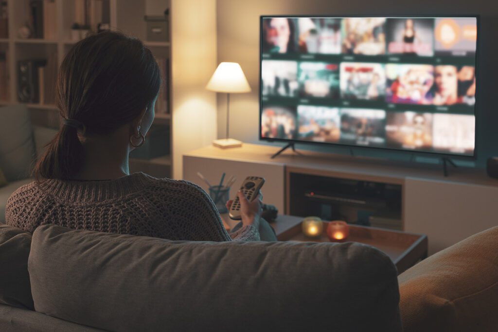 A woman browsing Youtube TV from her couch.