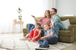 Happy family watching tv in the living room.